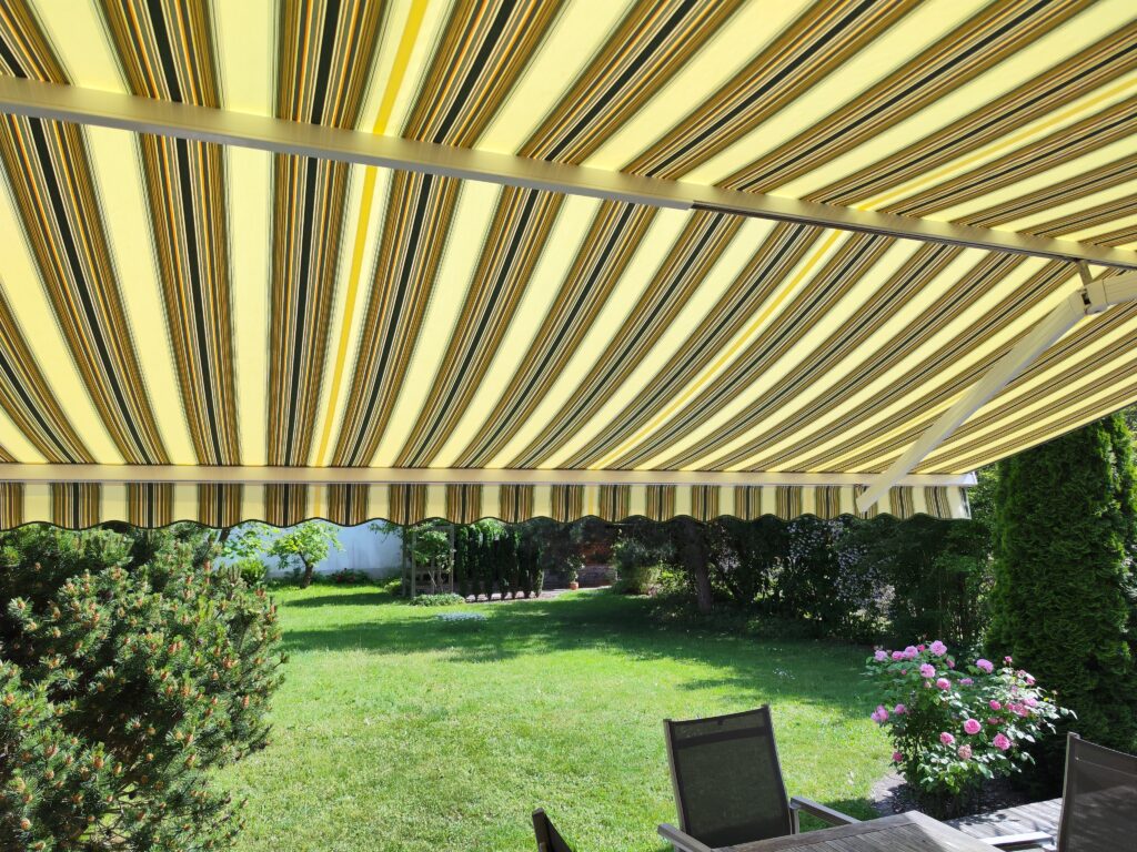 Einbau eines neuen Markisentuchs in St. Afra, Friedberg Ein zufriedener Kunde in St. Afra, einem schönen Stadtteil von Friedberg, freut sich über eine deutlich aufgewertete Terrasse. Wir hatten das Vergnügen, bei ihm ein neues Markisentuch zu installieren, das nicht nur optisch ein Highlight darstellt, sondern auch wieder optimalen Schutz vor Sonne und neugierigen Blicken bietet. Die Wahl des richtigen Tuchs war hier entscheidend, denn es sollte nicht nur zur Ästhetik des Hauses passen, sondern auch langlebig und witterungsbeständig sein. Nach einer ausführlichen Beratung und der Bemusterung verschiedener Stoffe fiel die Entscheidung auf ein hochwertiges Markisentuch, das nun die Terrasse des Kunden in neuem Glanz erstrahlen lässt und für viele angenehme Stunden im Freien sorgen wird. Sorgfältige Vorbereitung: Zerlegen und Reinigen der Kassetten Bevor das neue Tuch seine Bestimmung finden konnte, war eine sorgfältige Vorbereitung der bestehenden Markisenanlage notwendig. Um die Langlebigkeit und Funktionalität der gesamten Markise zu gewährleisten, haben wir die Kassetten, in denen das Tuch aufgerollt wird, komplett zerlegt. Dieser Schritt ist essenziell, um eine gründliche Reinigung aller Komponenten zu ermöglichen. Über die Jahre können sich in den Kassetten Staub, Schmutz, Spinnweben und andere Ablagerungen ansammeln, die nicht nur die Optik beeinträchtigen, sondern auch die Leichtgängigkeit und den Verschleiß der Mechanik beeinflussen können. Wir legten großen Wert darauf, alle Teile gründlich zu säubern und auf mögliche Abnutzungserscheinungen zu überprüfen, um sicherzustellen, dass die Markise nach dem Tuchwechsel wieder wie neu funktioniert. Professionelle Montage und Funktionsprüfung Nach der Reinigung und der fachgerechten Montage des neuen Markisentuchs erfolgte die abschließende Funktionsprüfung. Dabei wurde die Markise mehrfach ein- und ausgefahren, um sicherzustellen, dass alles reibungslos läuft. Auch die Endpunkte und die Neigung wurden präzise eingestellt, um den gewünschten Schattenwurf zu gewährleisten und das Tuch optimal zu spannen. Unser Ziel ist es immer, höchste Qualität in der Ausführung zu liefern und unseren Kunden ein Produkt zu übergeben, an dem sie lange Freude haben werden. Der Kunde in St. Afra war sichtlich begeistert vom Ergebnis und kann nun die sonnigen Tage in Friedberg unter seiner frisch aufgerüsteten Markise in vollen Zügen genießen.