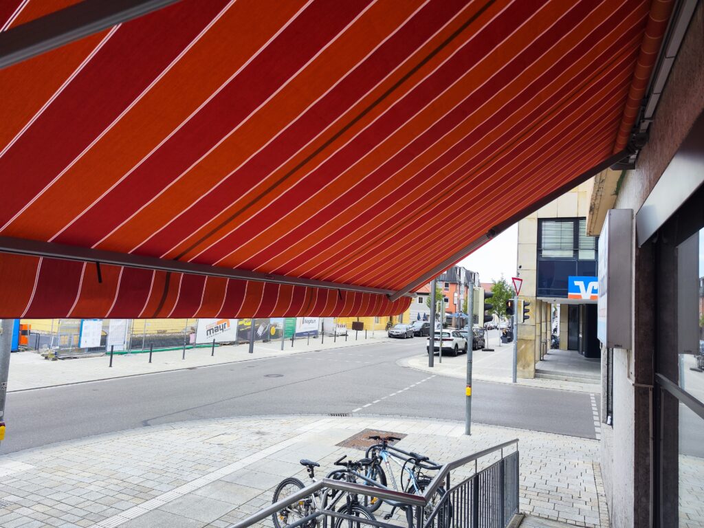 Handwerkliche Präzision bei der Installation des neuen Tuches für die Buchhandlung Schmid.