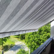 Das neu montierte, graue Markisentuch an einer modern gestalteten Terrasse in Augsburg.