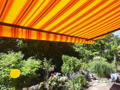 Die erfolgreich erneuerte Markise mit einem strahlenden neuen Stoff an einer Terrasse in Maingründel.