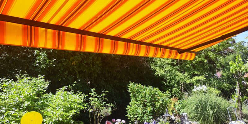 Die erfolgreich erneuerte Markise mit einem strahlenden neuen Stoff an einer Terrasse in Maingründel.