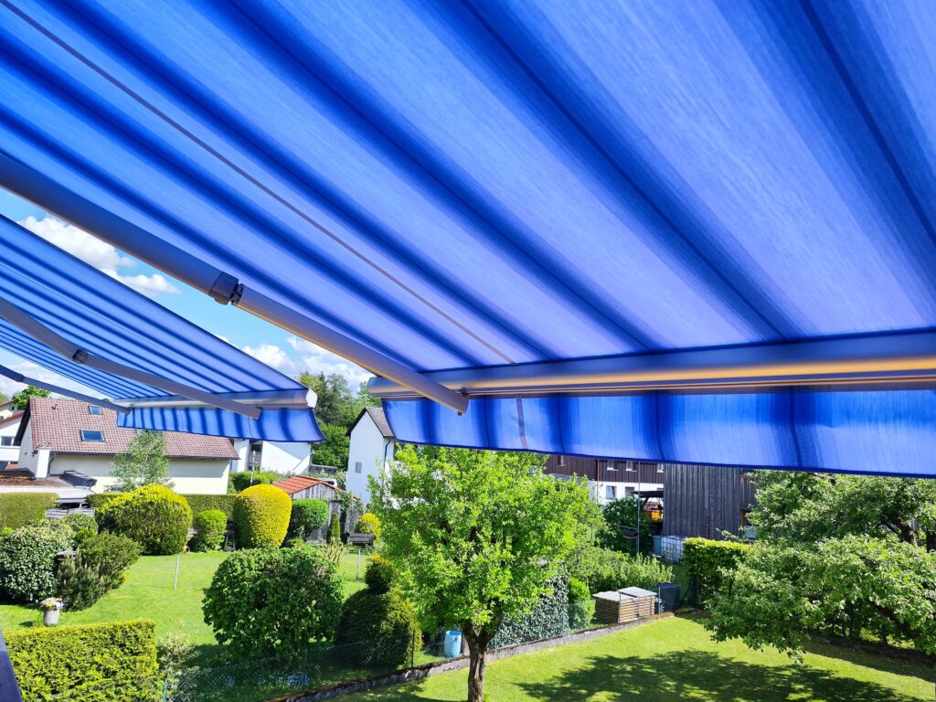 Hochwertige Markisentücher mit blauen Multistreifen nach dem Tuchwechsel für Kunden in Tutzing.